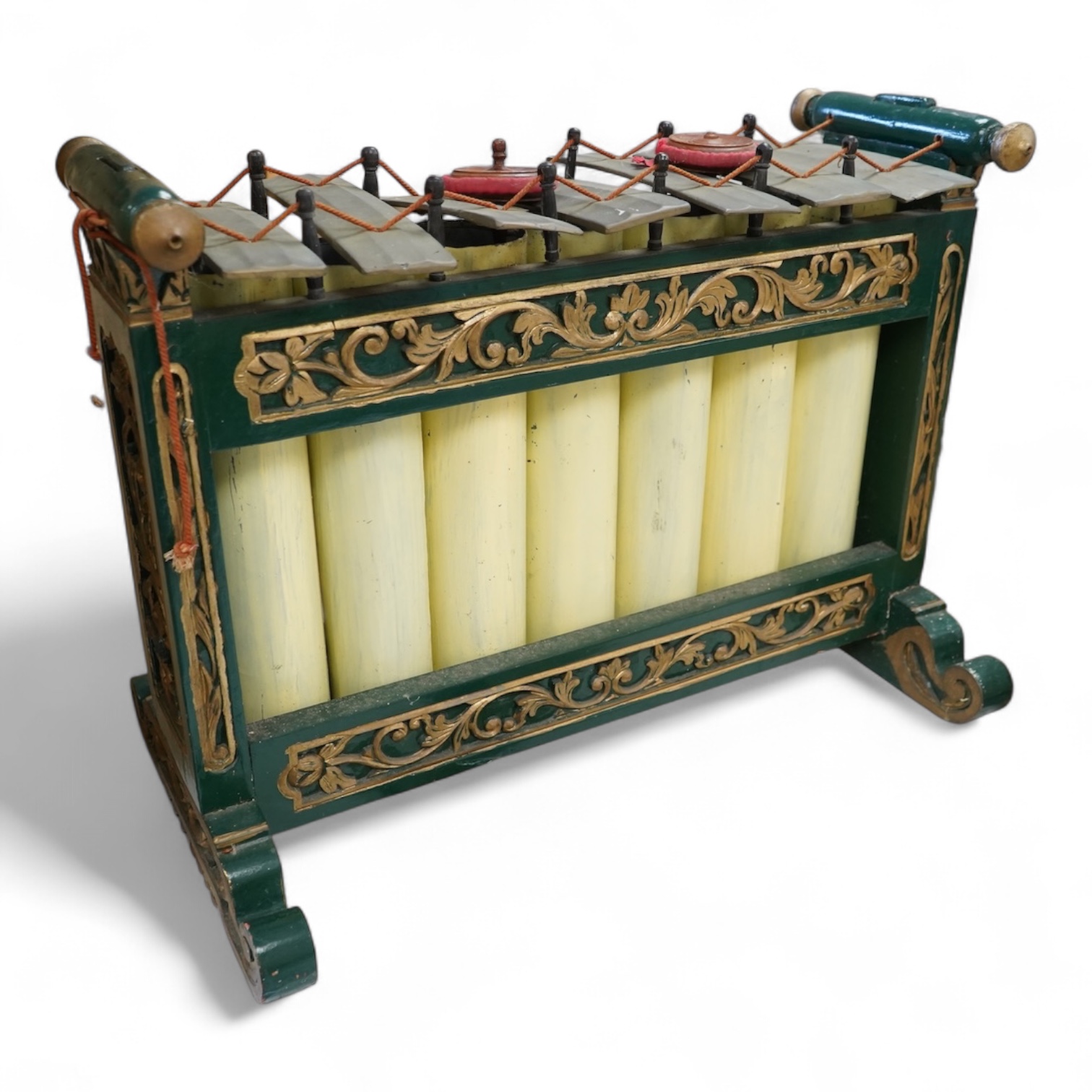 A green and gold painted wooden Javanese Gamelan Slenthem musical instrument, 61cm wide, 46cm high, together with two hammers